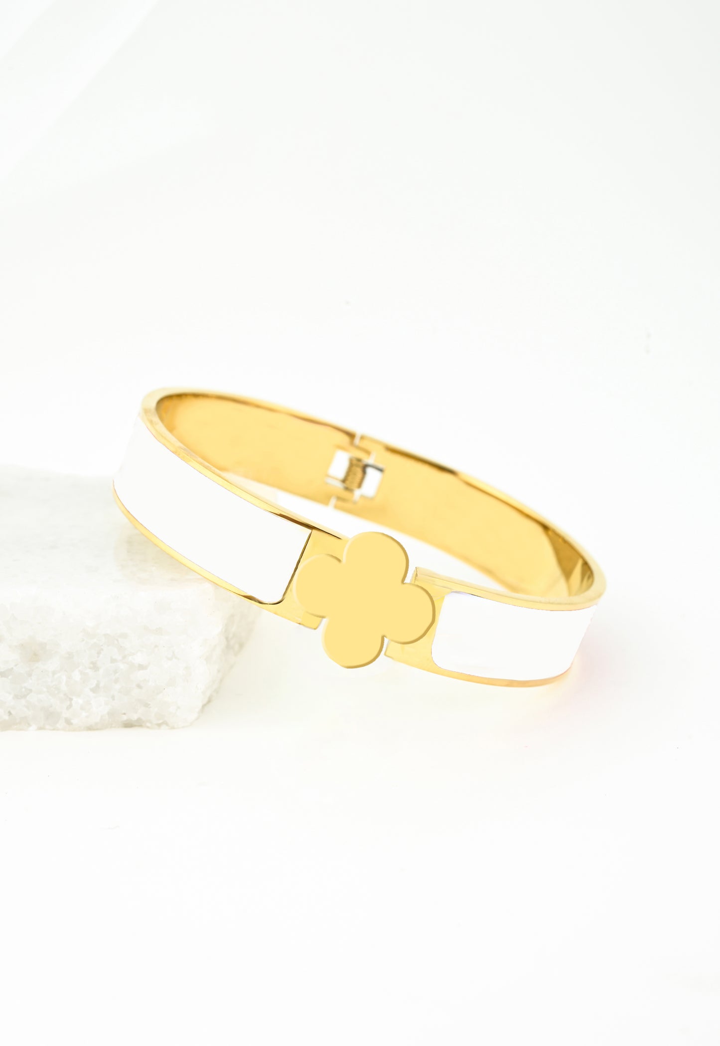 White bracelets with a gold clover closure