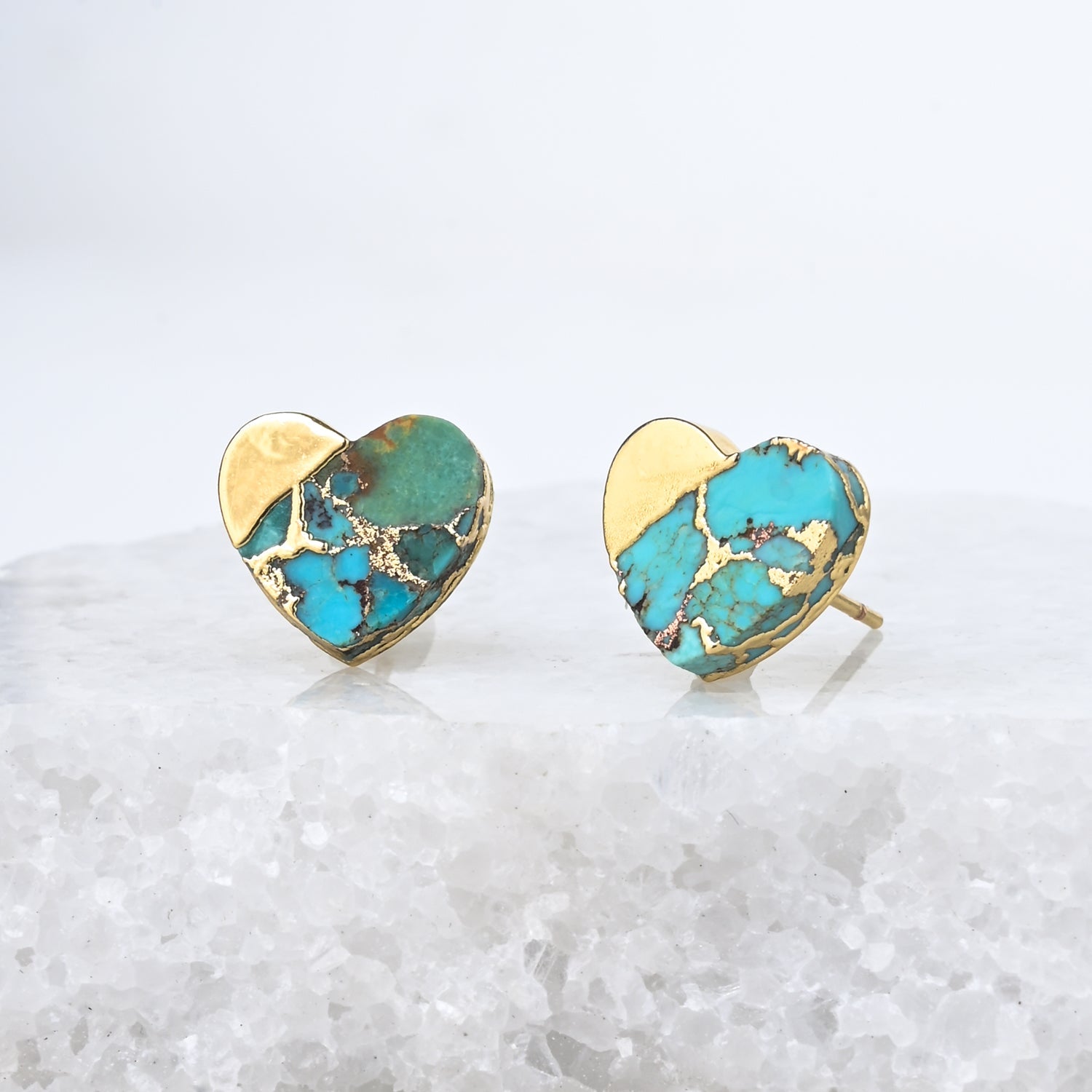 Heart-shaped earrings with turquoise and gold finish on a white background