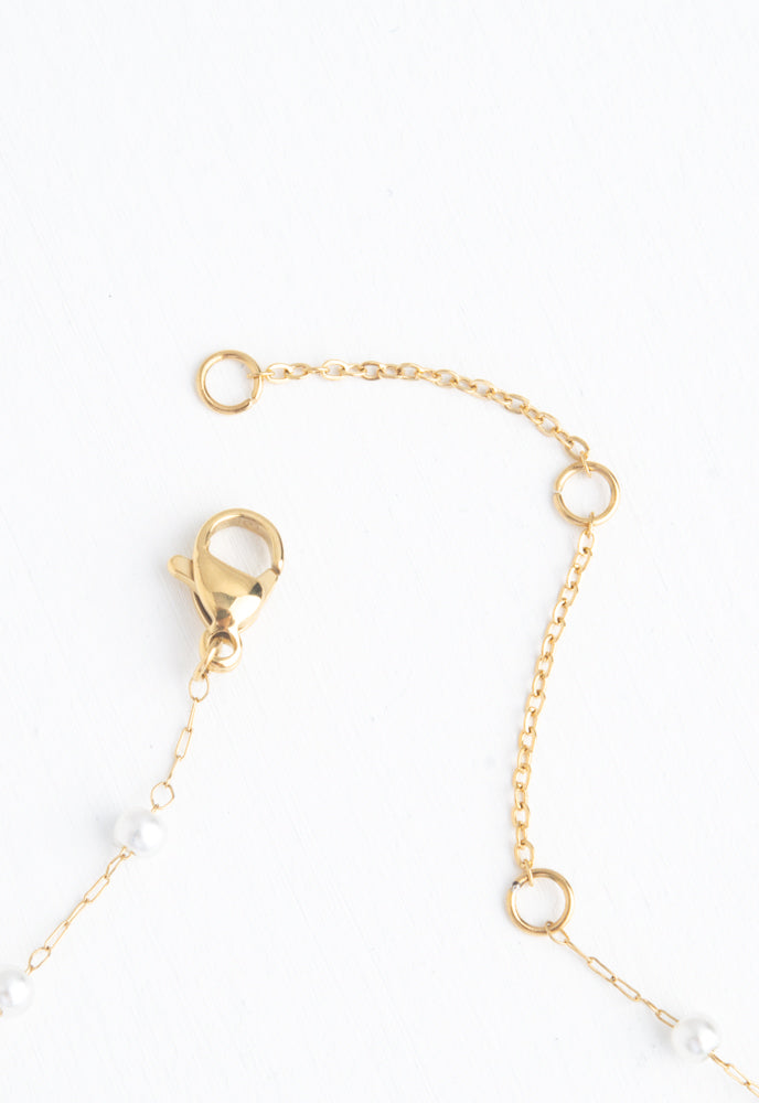 Floating cross, o-centered on chain with loosely spaced pearls necklace